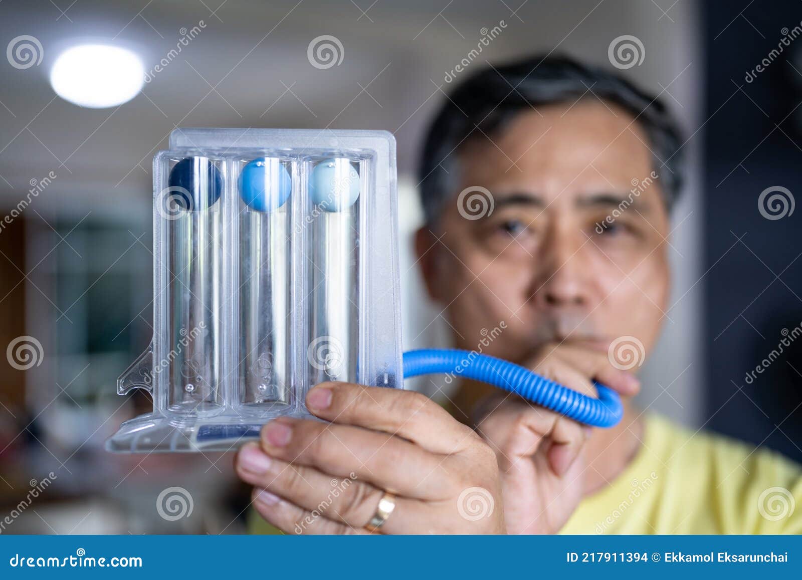 Old Man Uses a Triball Incentive Spirometer for Check His Lung