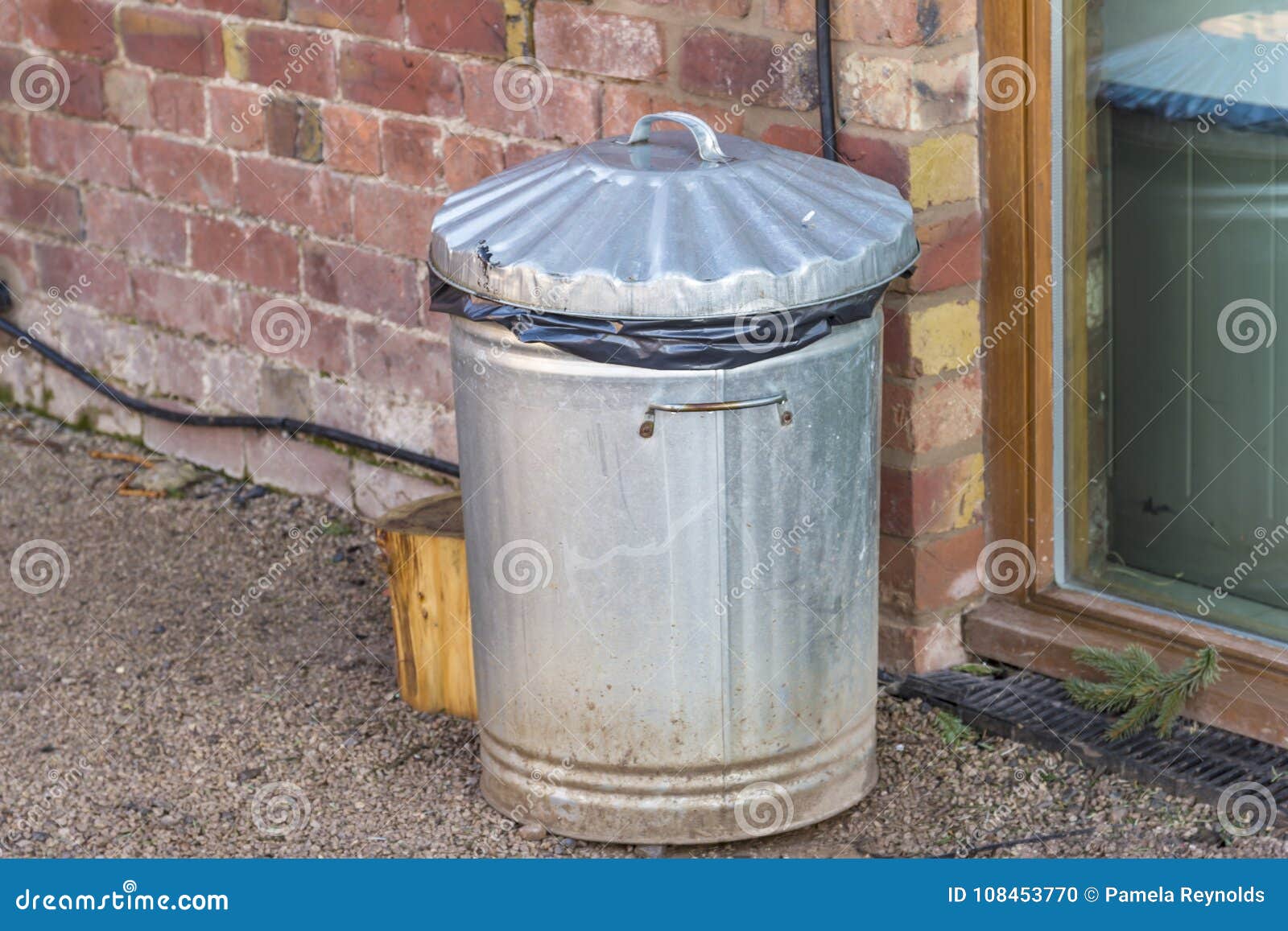 Old Metal Trash Can by a Brick Wall Stock Photo Image of object