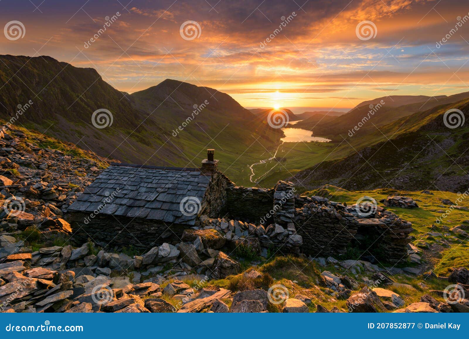 old mountain shelter warnscale bothy with beautiful sunset over buttermere in the lake district, uk.