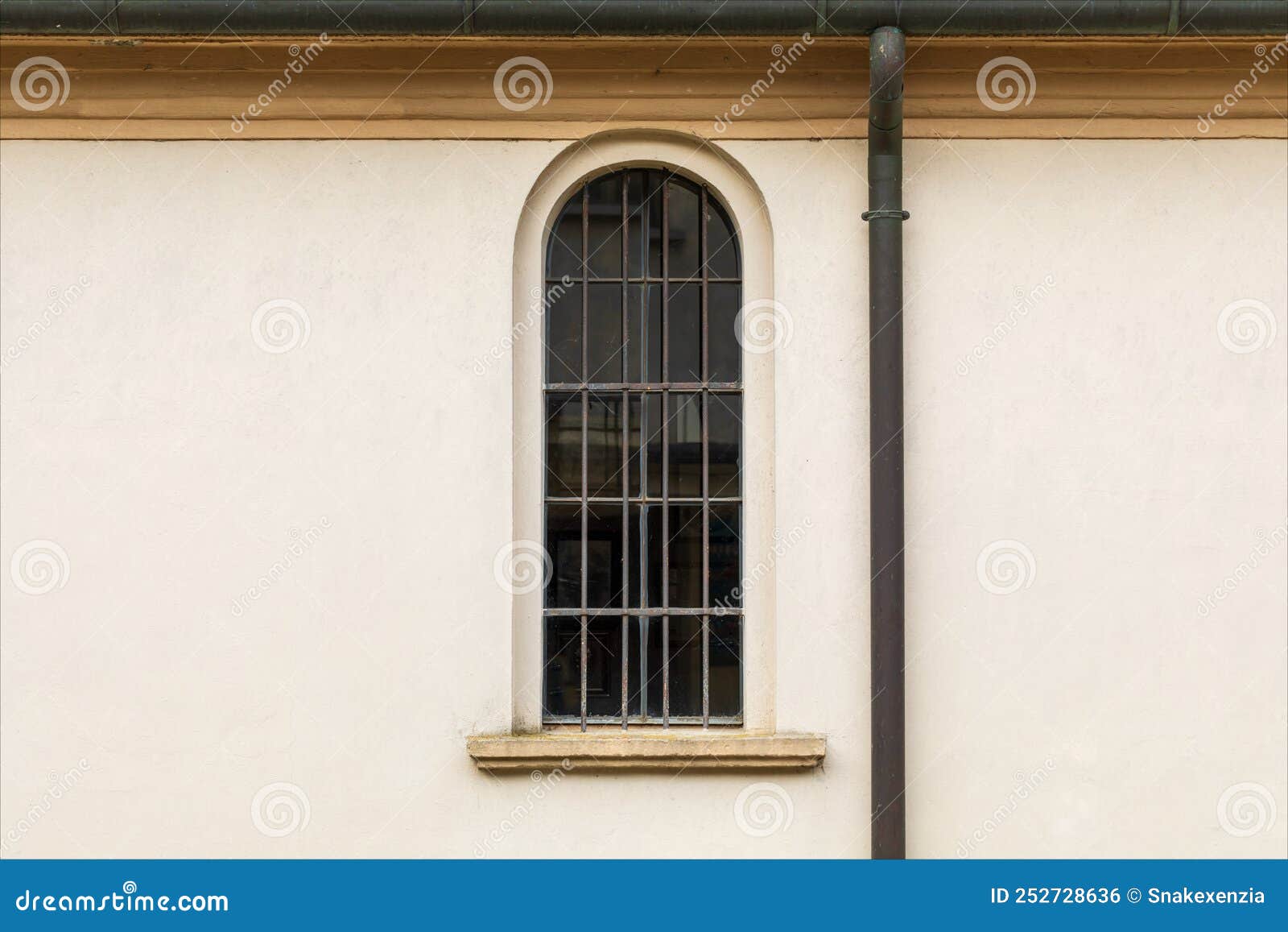 old narrow and arched glass window on facade of religious building.