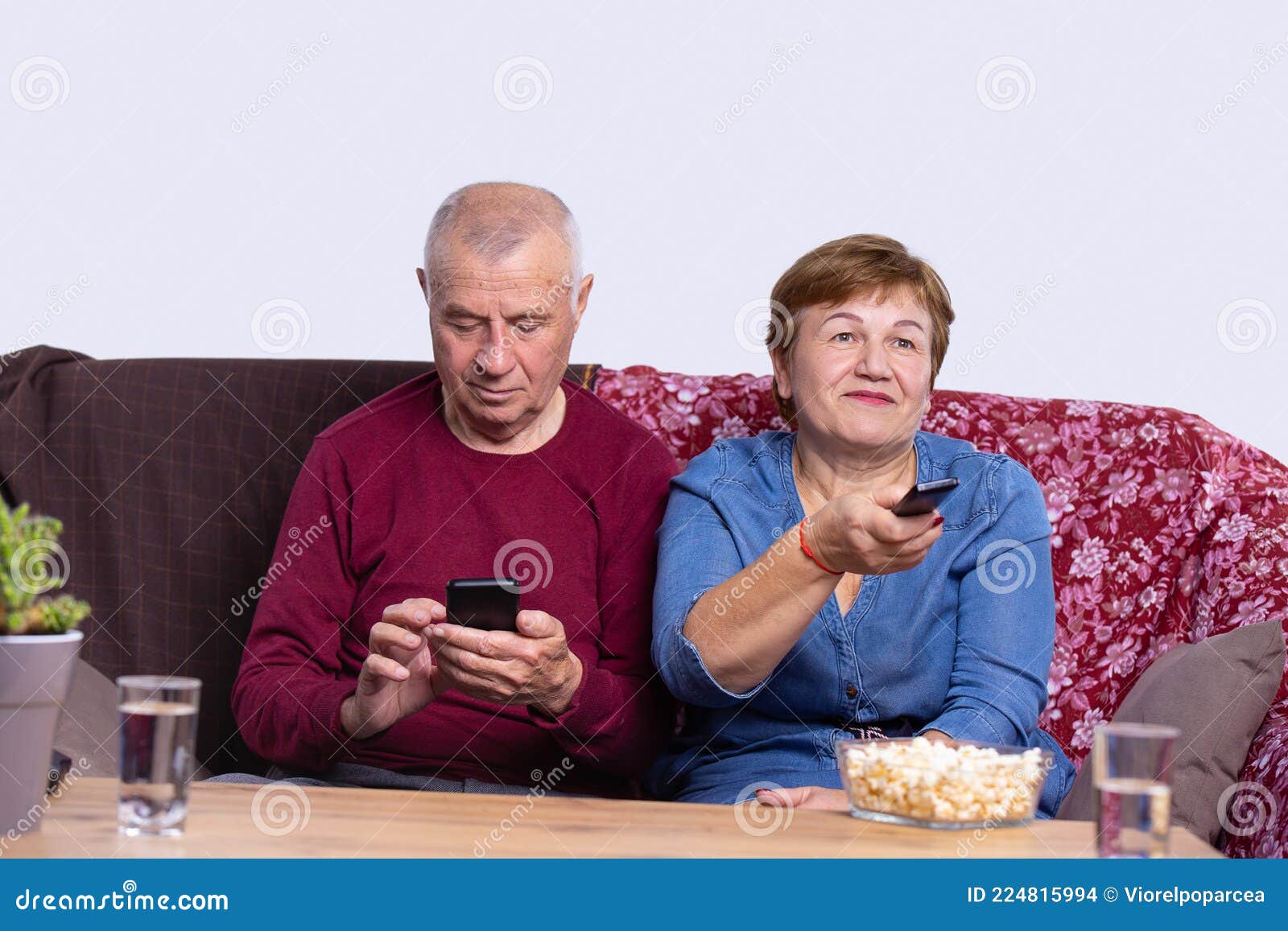 An Old Nice Couple are Resting Sitting on the Sofa, Wife is Switch