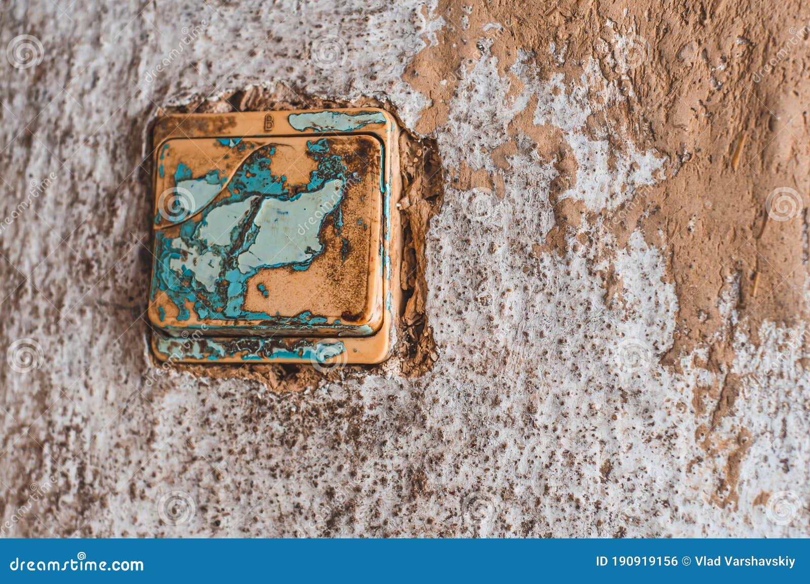 Old Plastic Light Switch with Peeling Paint on a Clay Wall Stock Photo