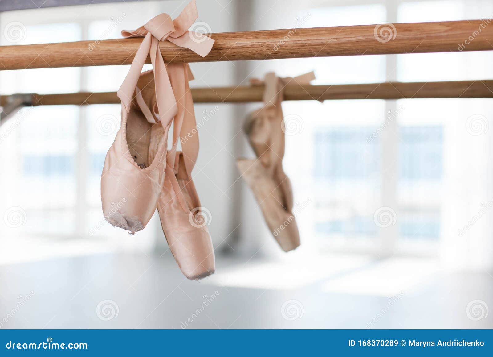 Old Pointe Shoes Hang on Ballet Wooden Barre in Dance Class Room