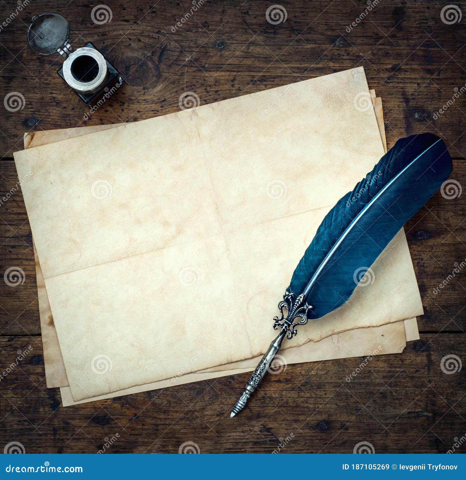 old quill pen, and old paper blank sheet and vintage inkwell on wooden desk in the old office . retro style. conceptual background