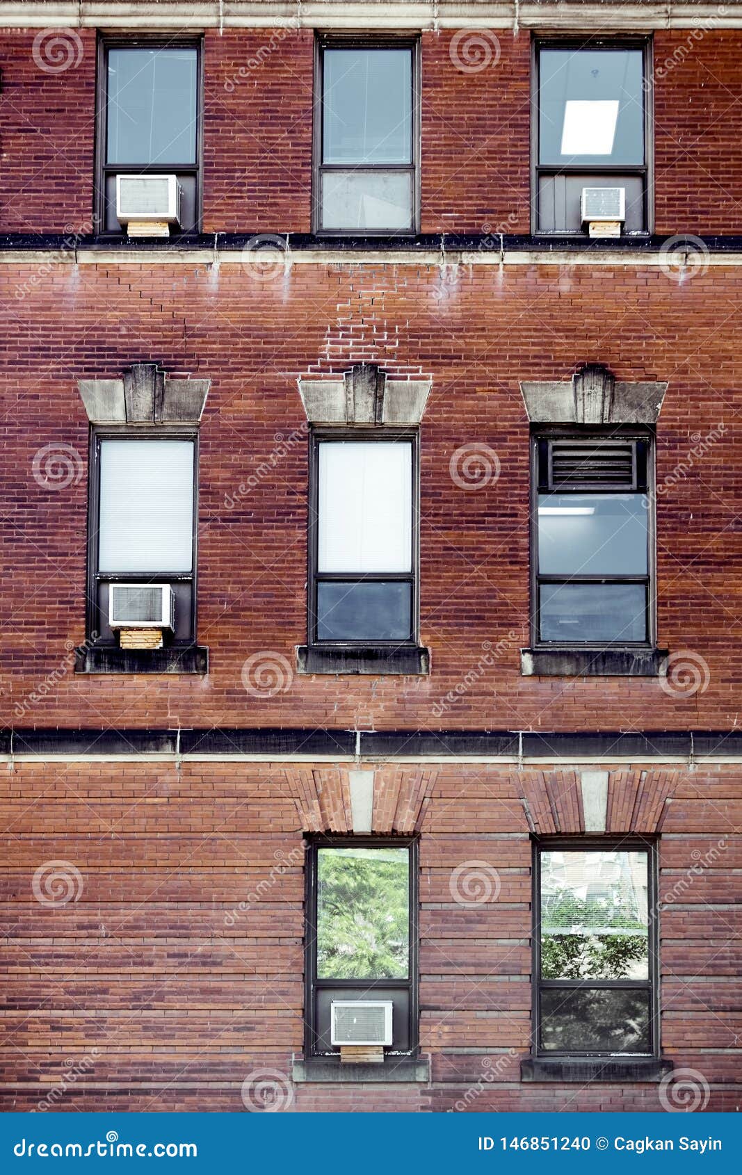 Old Red Brick Wall with Rectangle Windows and Air Conditioners Mounted