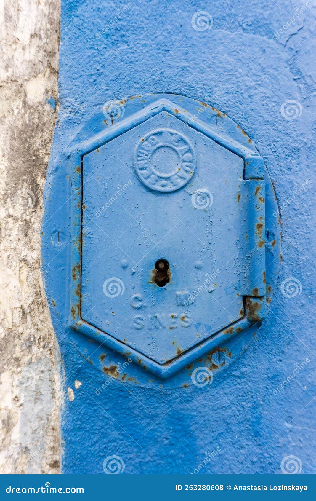 old rusty blue painted iron lid of a valve box of the servico de agua