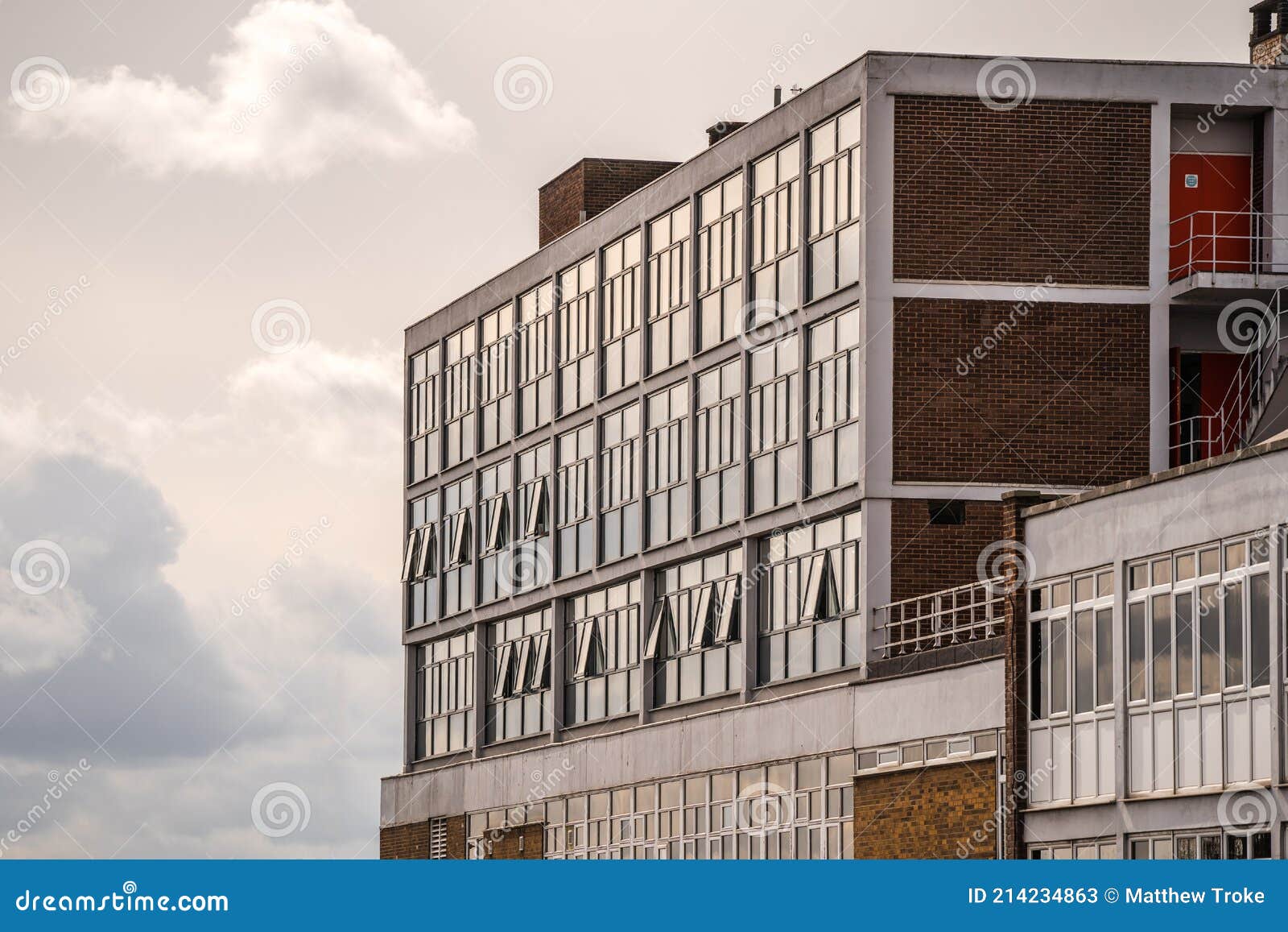 old 1970`s concrete and brick office building block with sun shining in need of regeneration project to modernise
