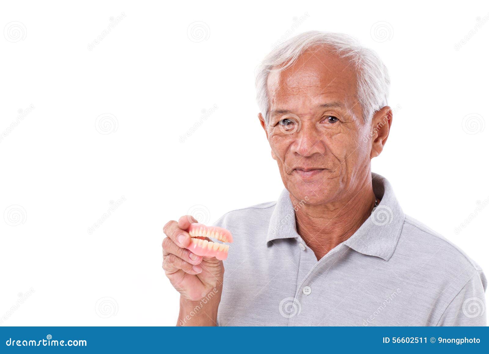 old senior man with hand holding denture