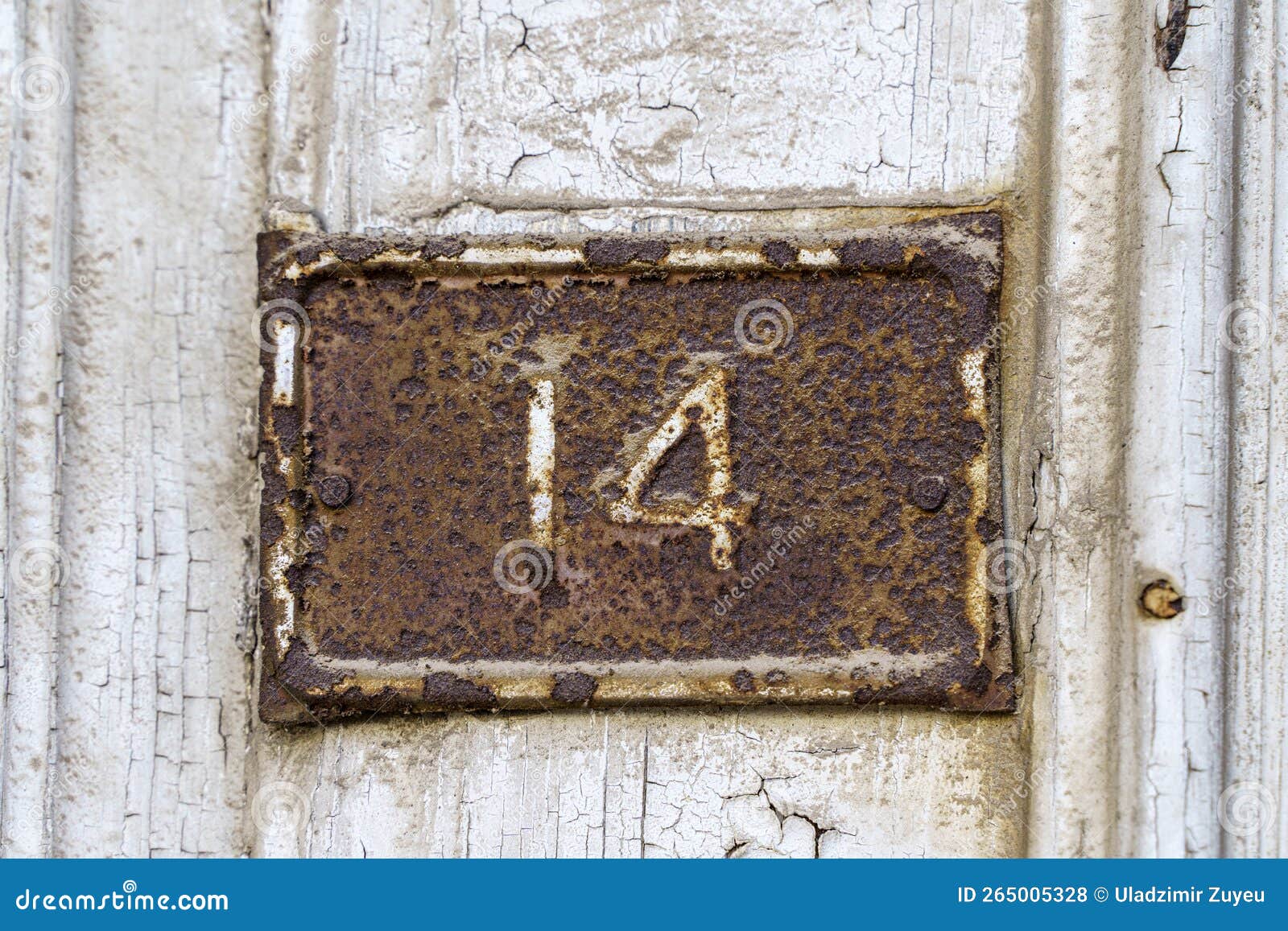 old sign with the house number 14 on the background of the wall.