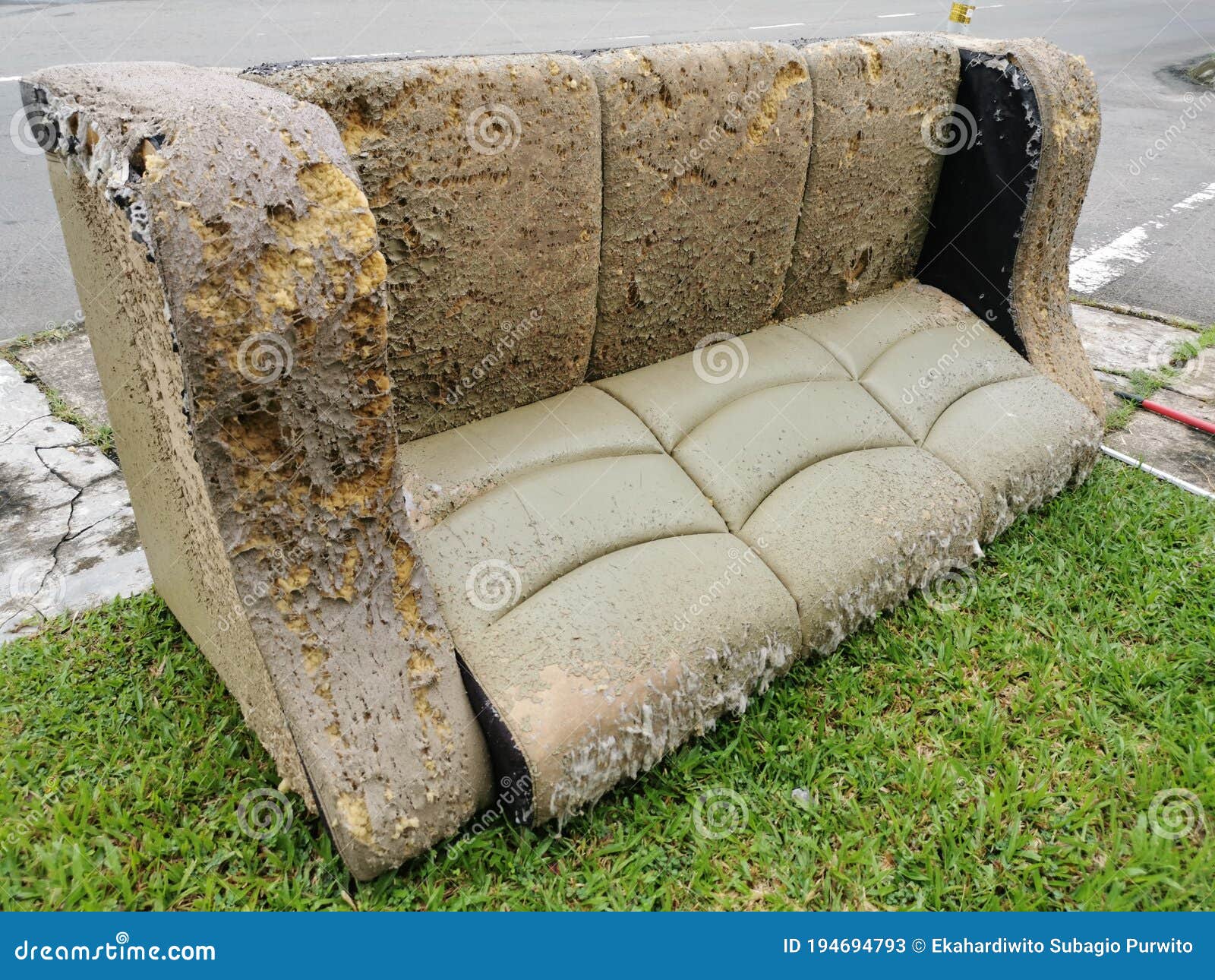 Old Sofa at Apartment Garbage Collection Area by the Road Side. Stock