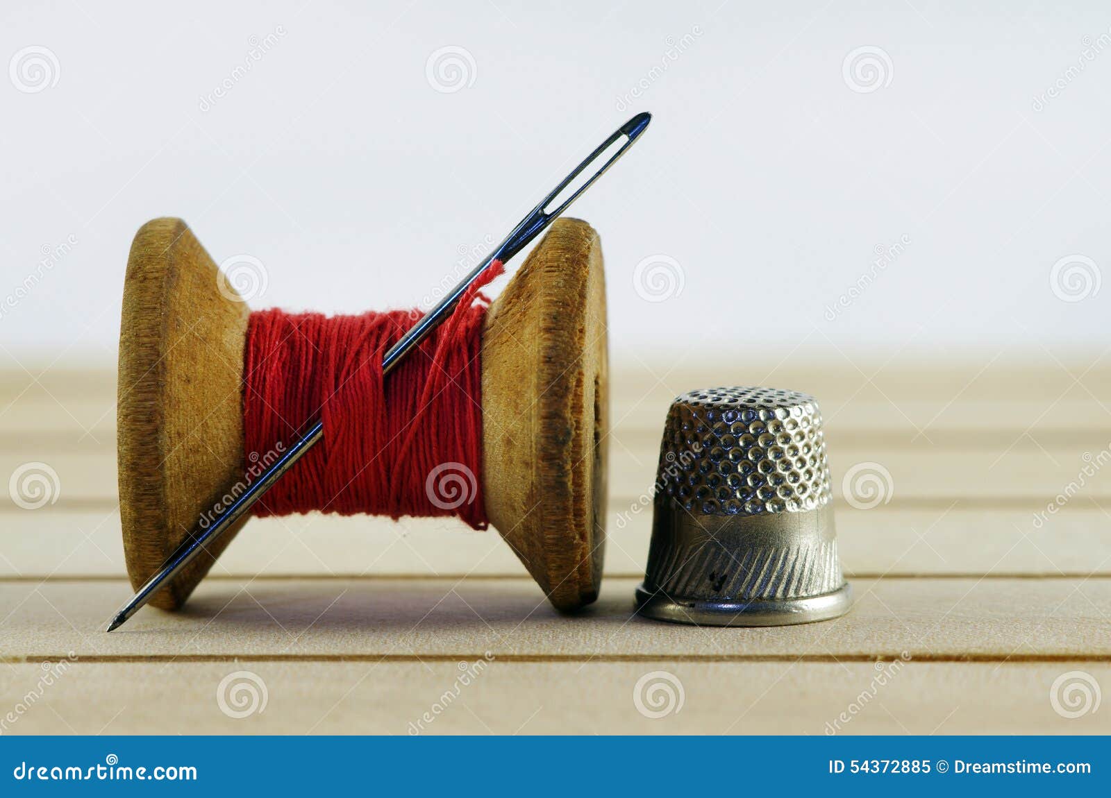 Old spool of thread with needle closeup. Tailor s work table. textile or fine cloth making.