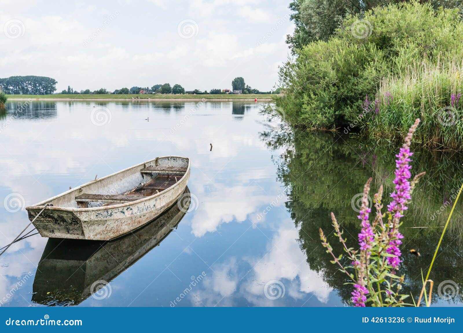 old steel rowboat reflected in the water stock photo