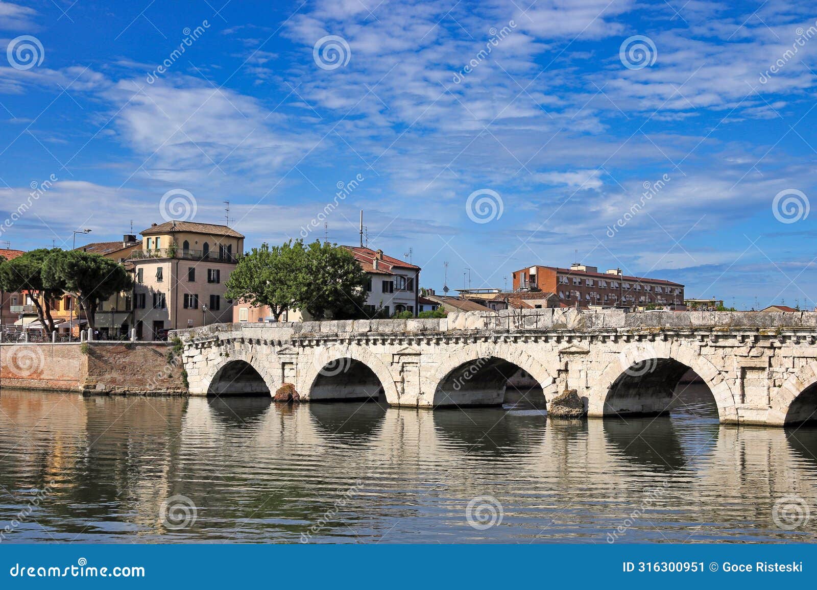 old stone tiberius bridge and buildings in rimini