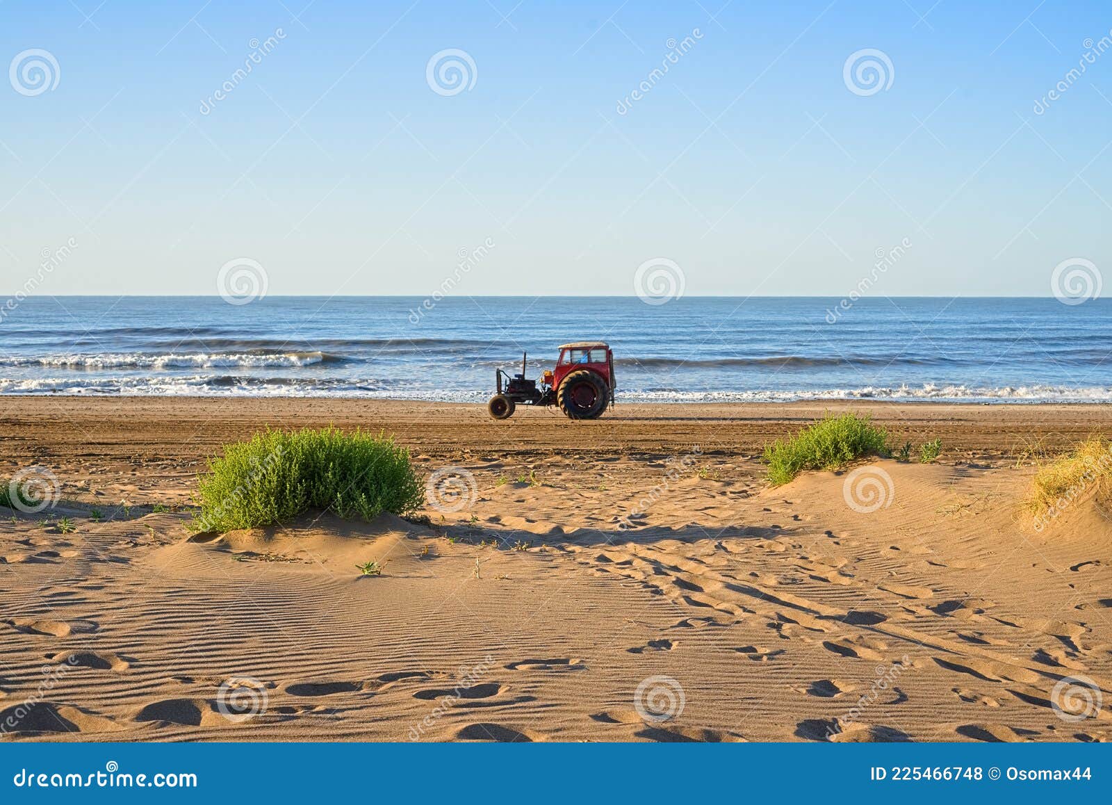 old tractor used to tow fishing boats circulated on the beach.