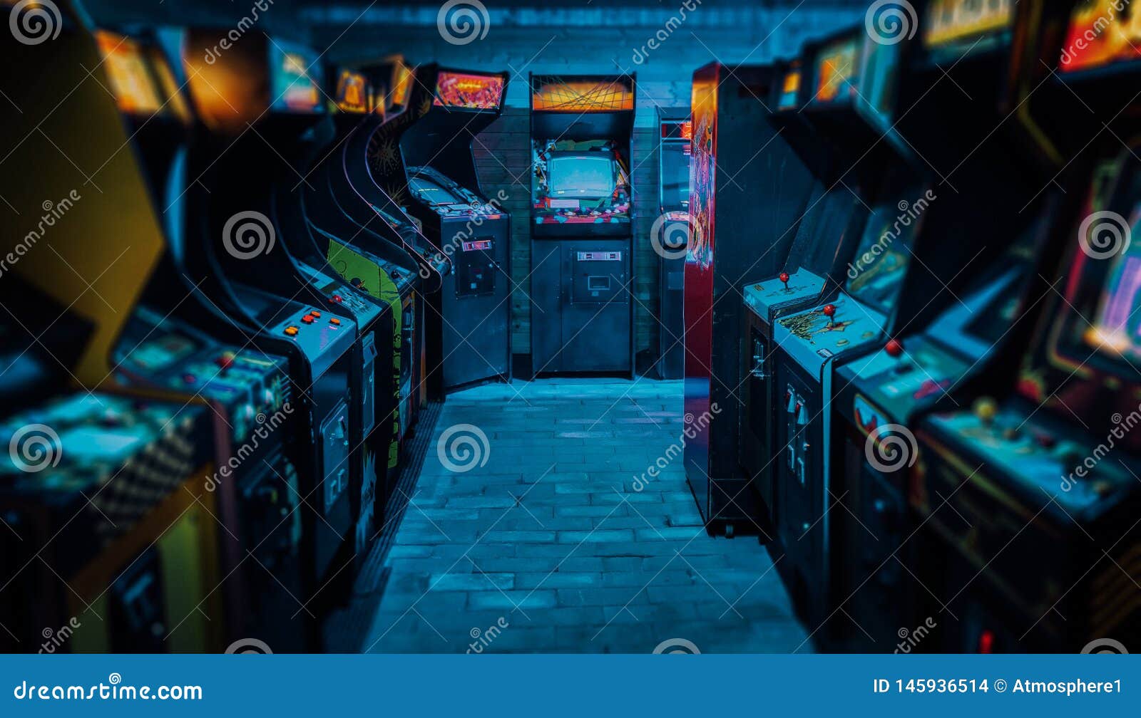 old vintage arcade video games in an empty dark gaming room with blue light with glowing displays and beautiful retro 