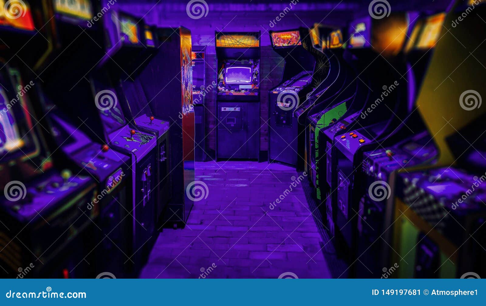 old vintage arcade video games in an empty dark gaming room with purple light