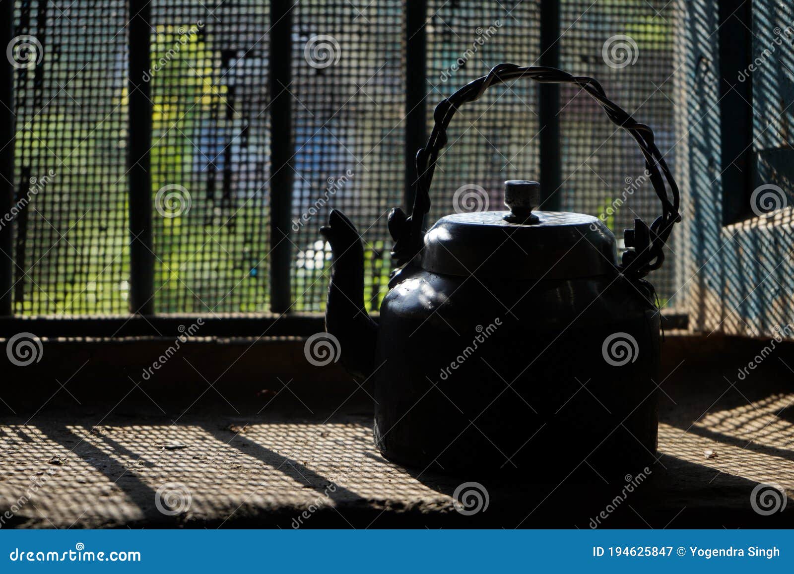 Old and Vintage Black Kettle Kept Near the Window from Where Sun Rays