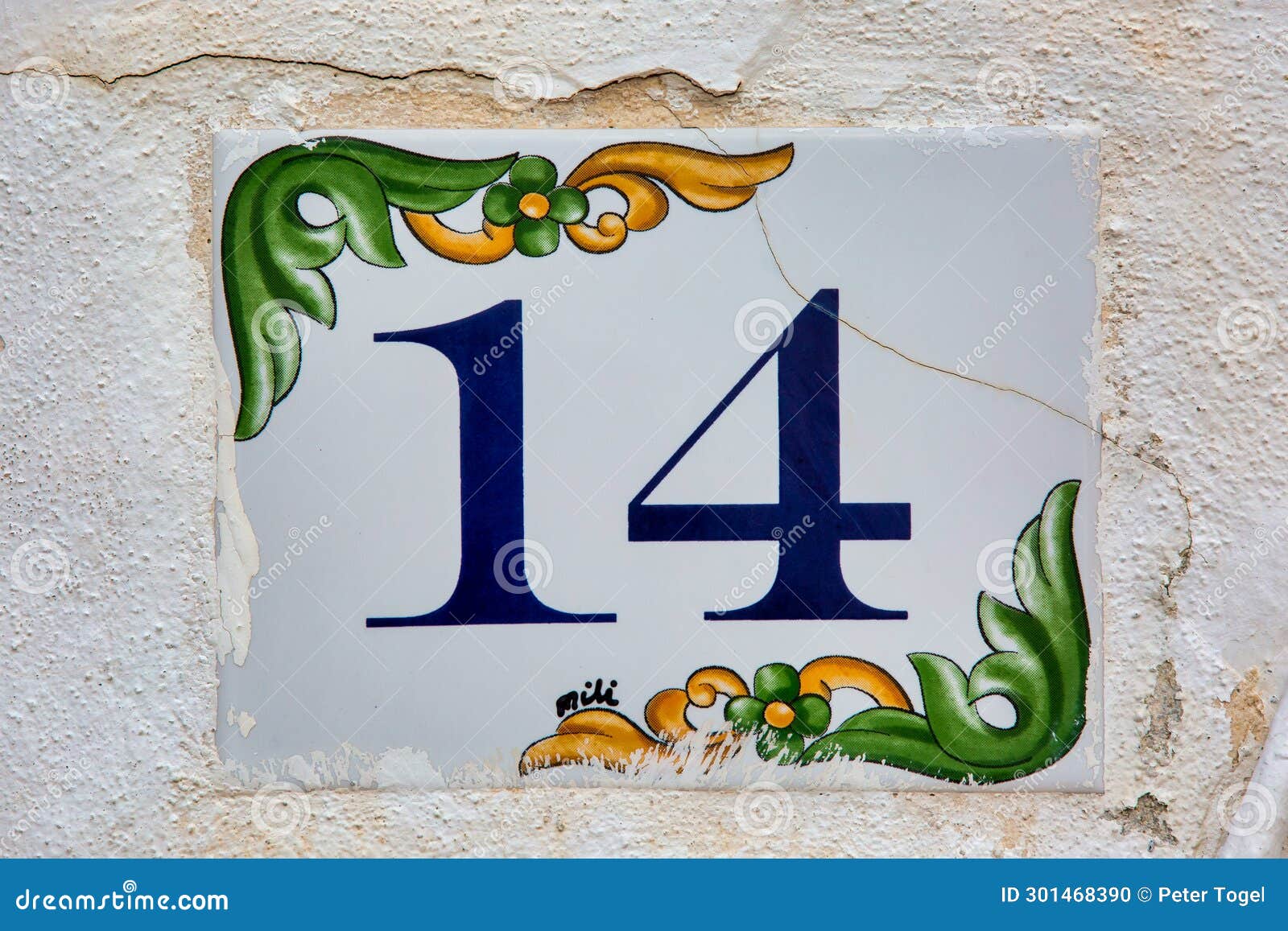 old weathered house number 14, tile on wall