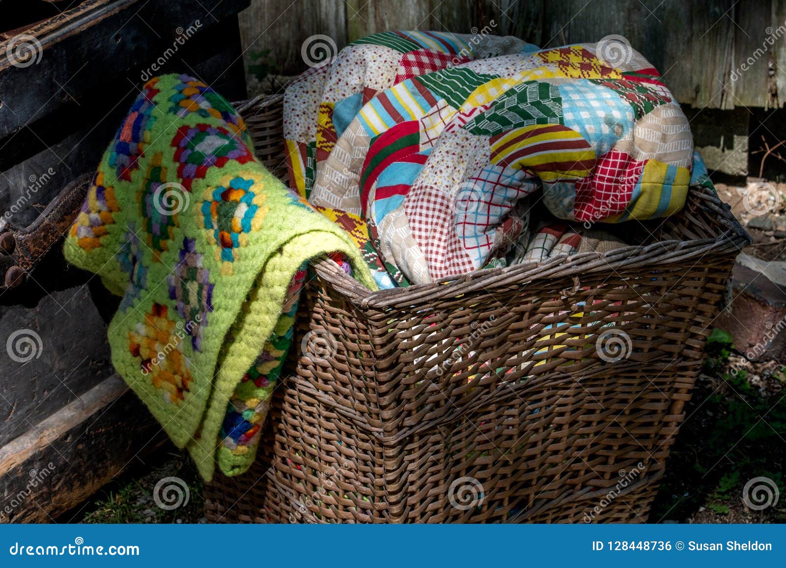 Old Wicker Basket Filled with Hand Made Quilts and Blankets Stock Photo