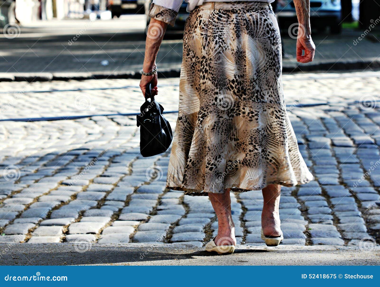 old woman crosses the street