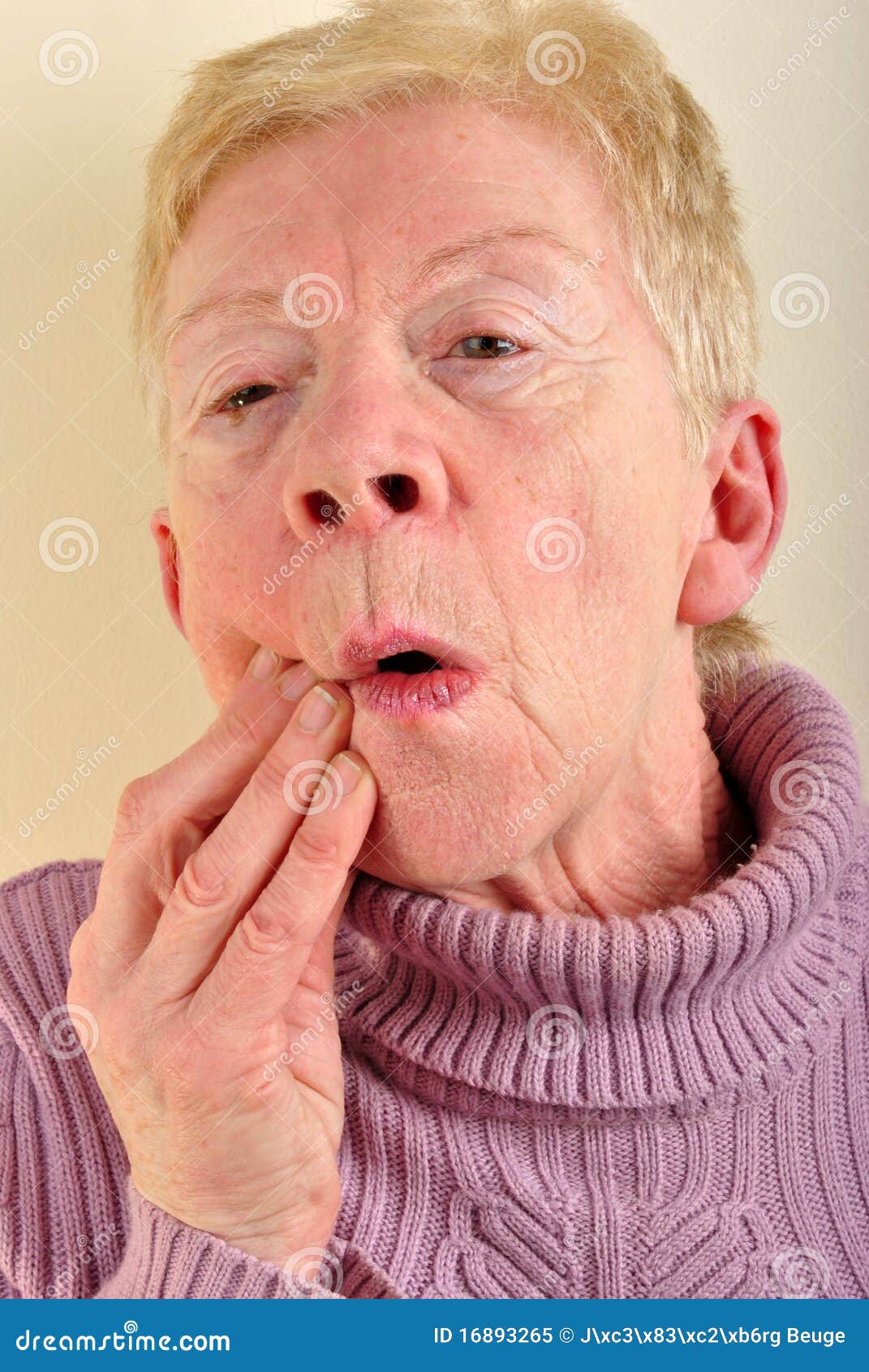 old woman holding her painful jawbone