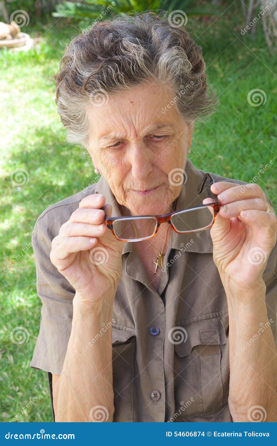 An Old Woman Looks At Her Eye Glasses Stock Photo - Image ...