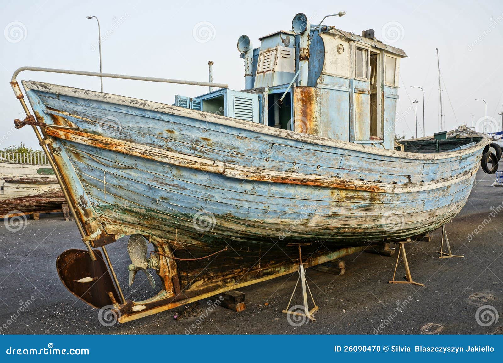 Deserted rusty old and broken wooden boat on the coast of a ocean 