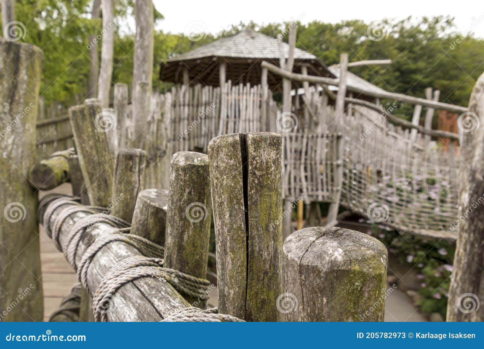 Old Wooden Cabins with a Suspension Bridge Made of Rope and Wood