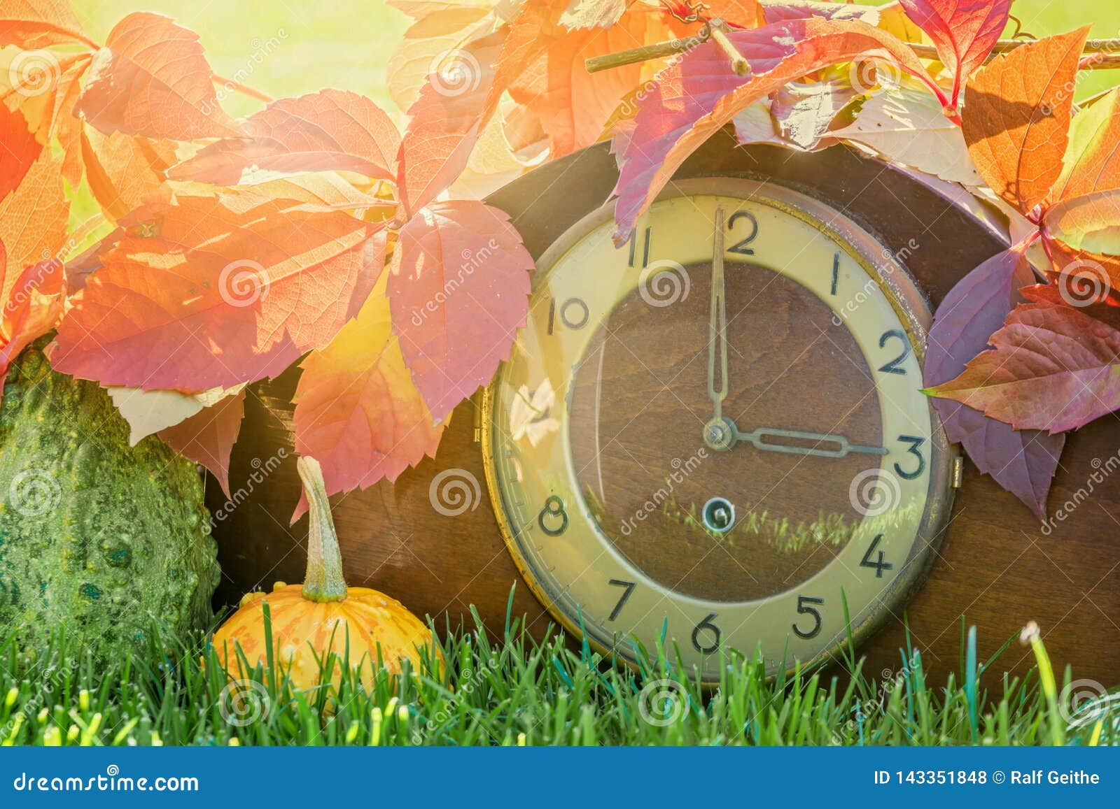 Clock in the Colorful Autumn Leaves As a Symbol of the Time Change