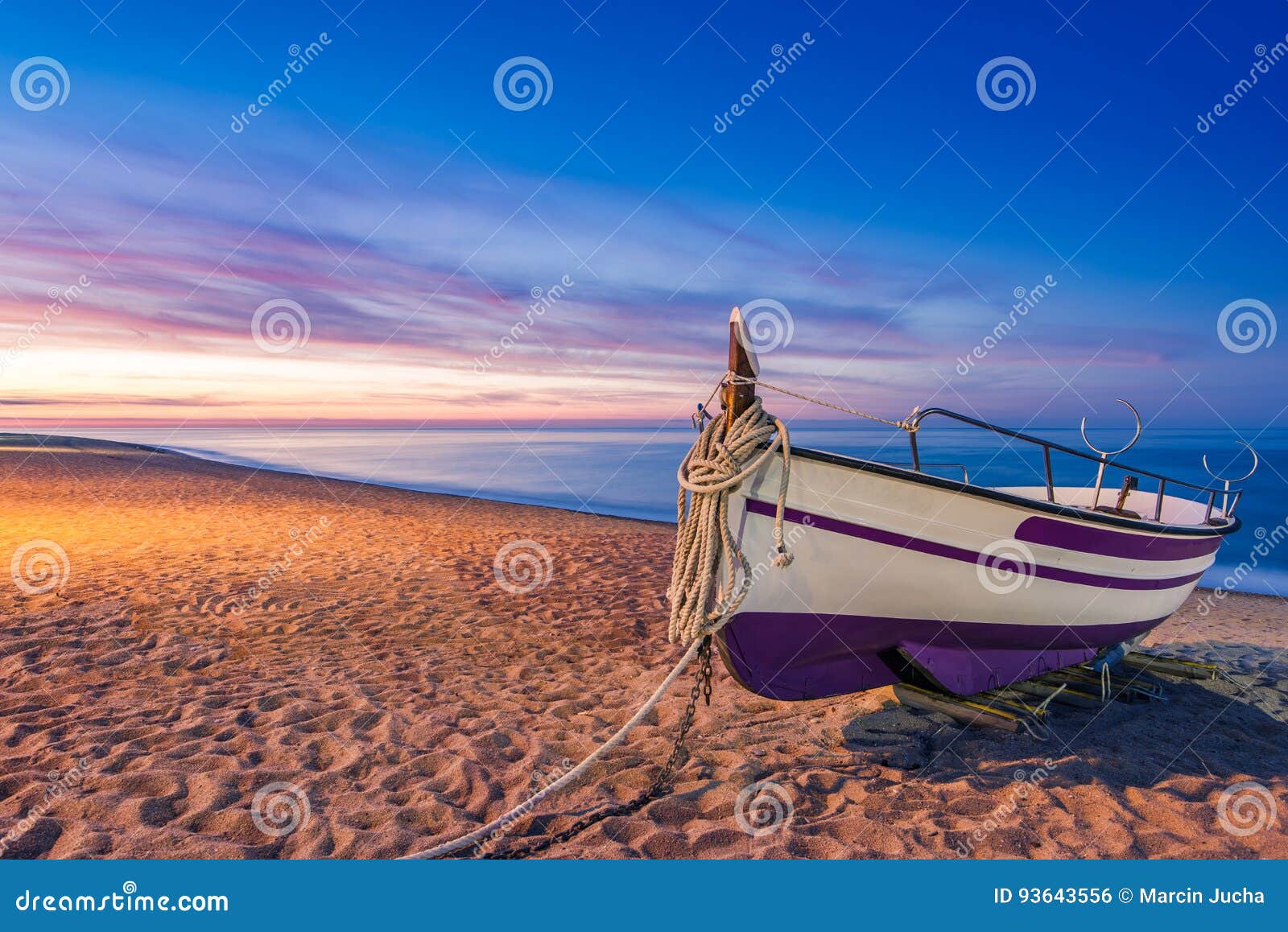 old wooden fishing boat on beach at sunrise