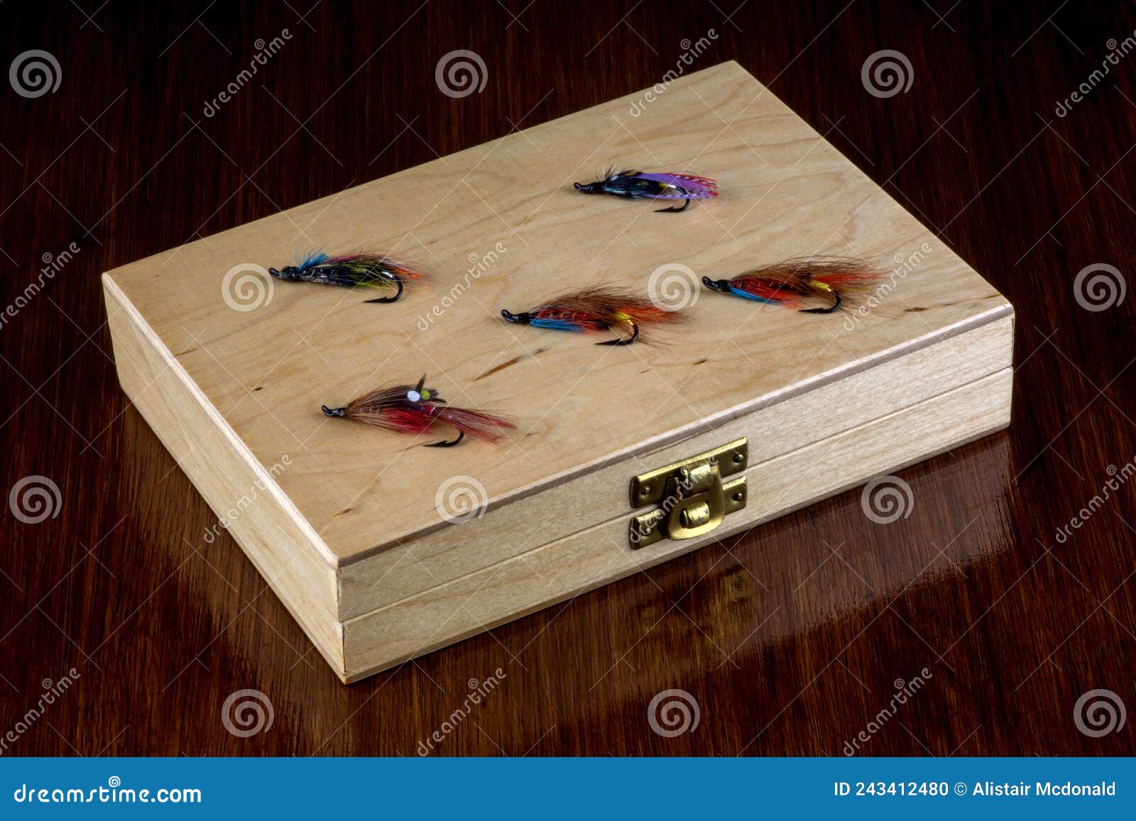 Old Wooden Fishing Fly Box with Salmon Flies on a Wooden Table Top