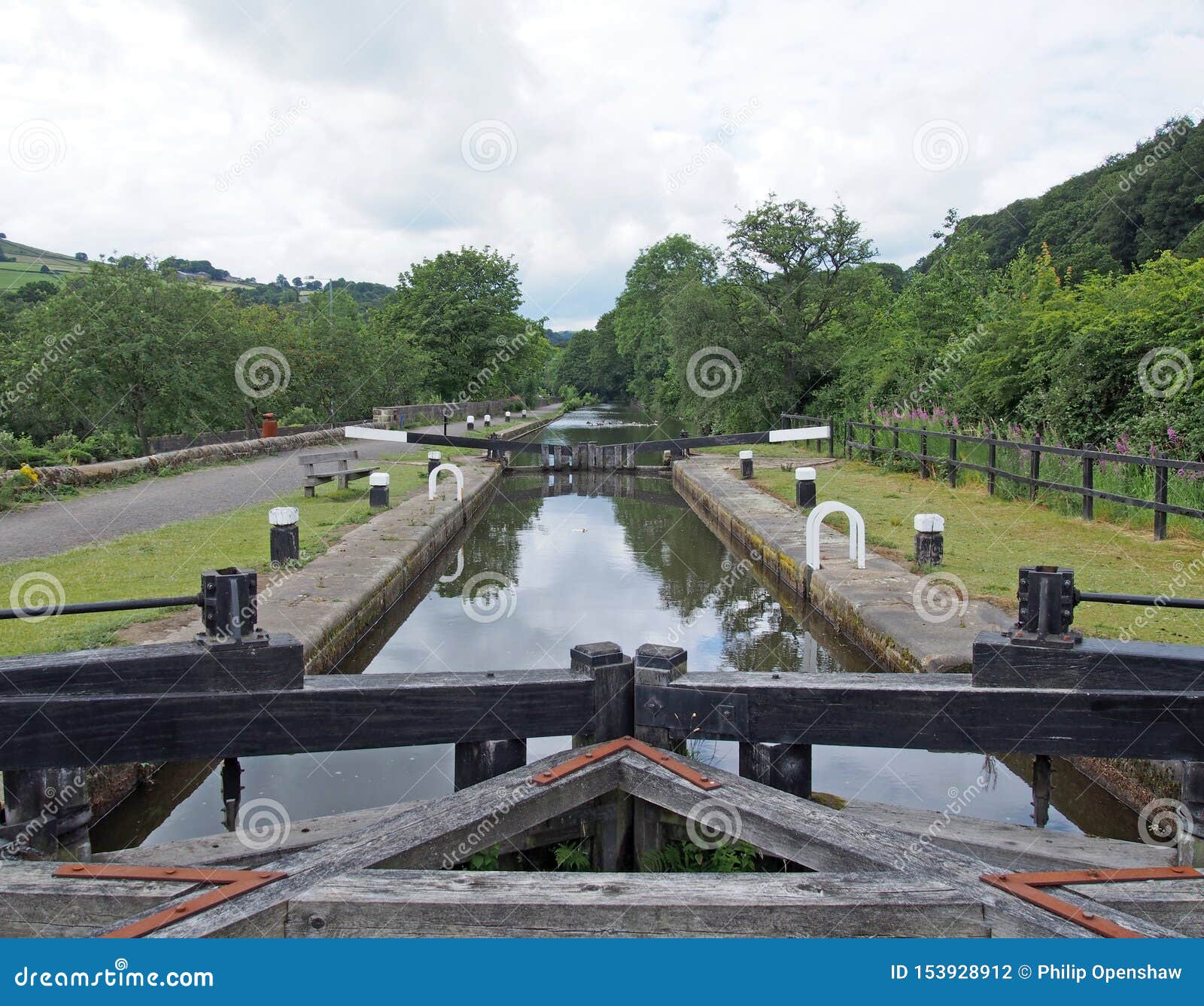 wooden lock gates on the rochdale canal outside mytholmroyd surrounded by trees and fields in the calder valley in west