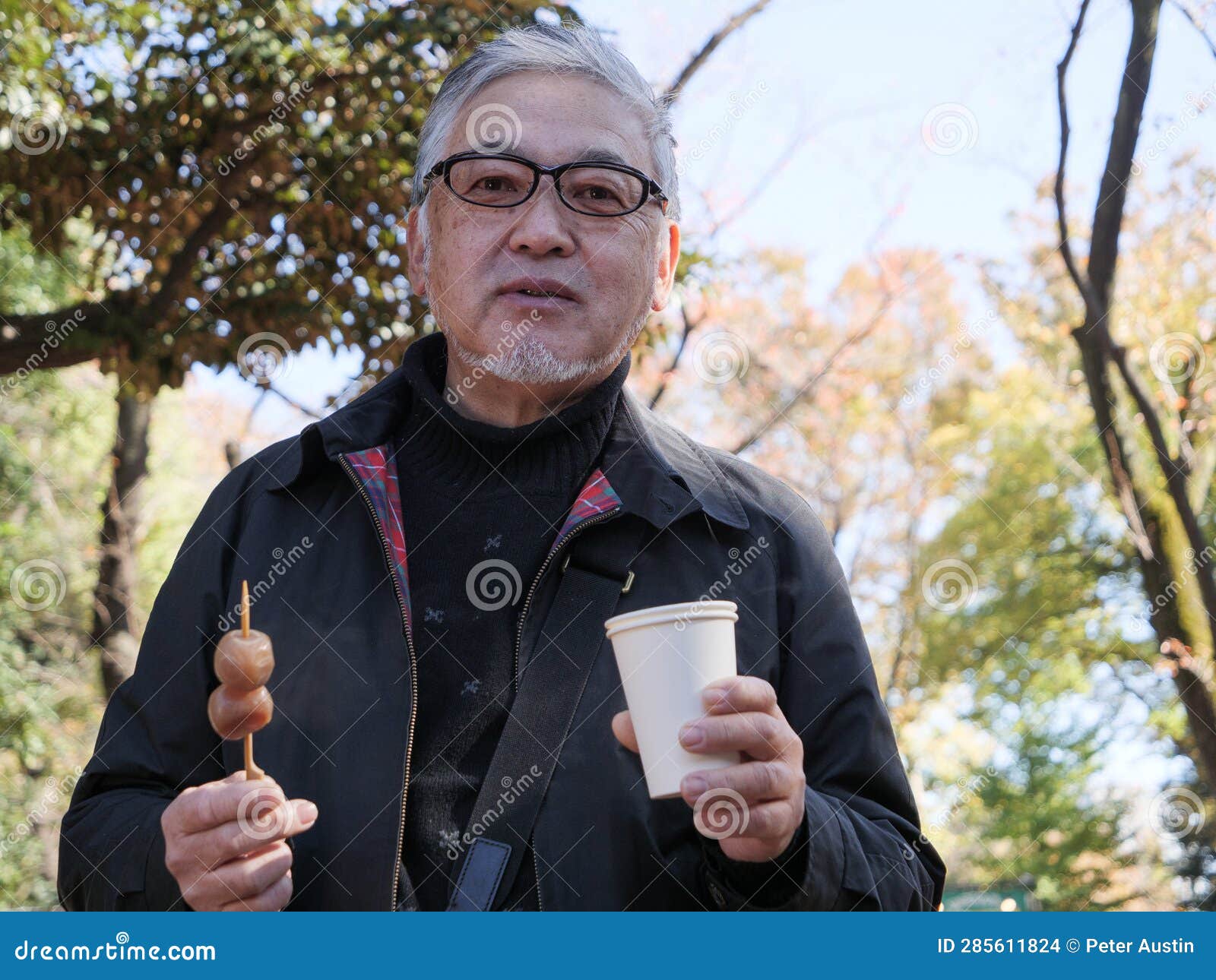 An Older Japanese Man Eating Dango and Drinking Coffee Stock Photo