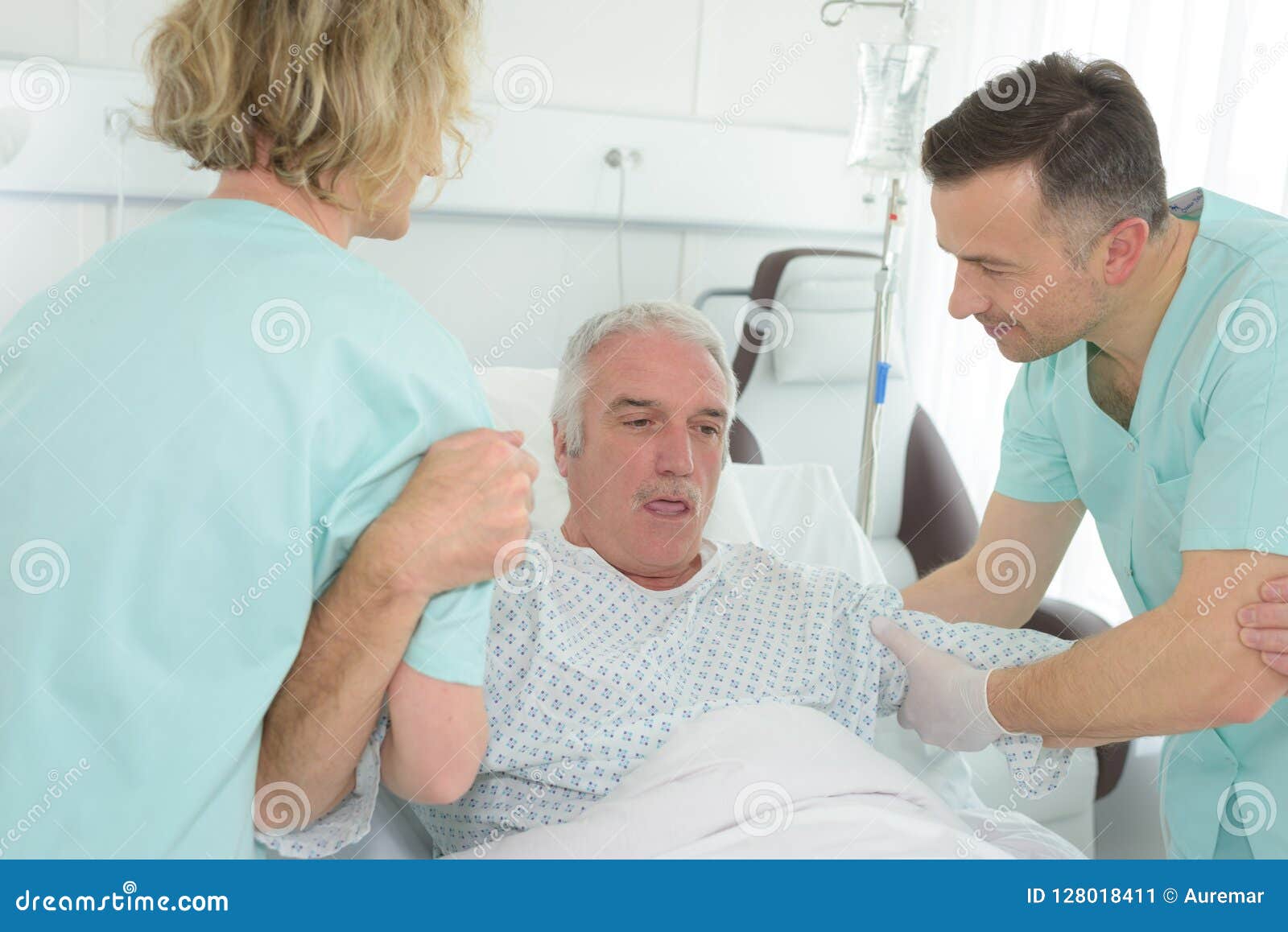 Older Man Lying in Hospital Bed with Nurses Helping Him Stock Image Image of hospital, sadness
