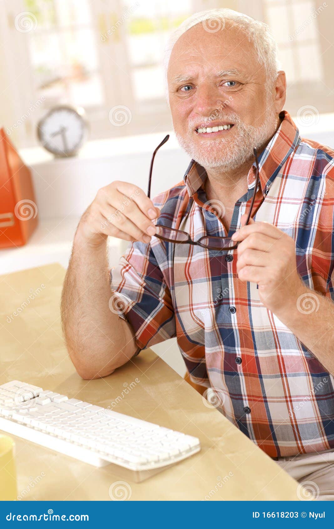 Older Man Putting on Glasses at Desk Stock Image Image of camera