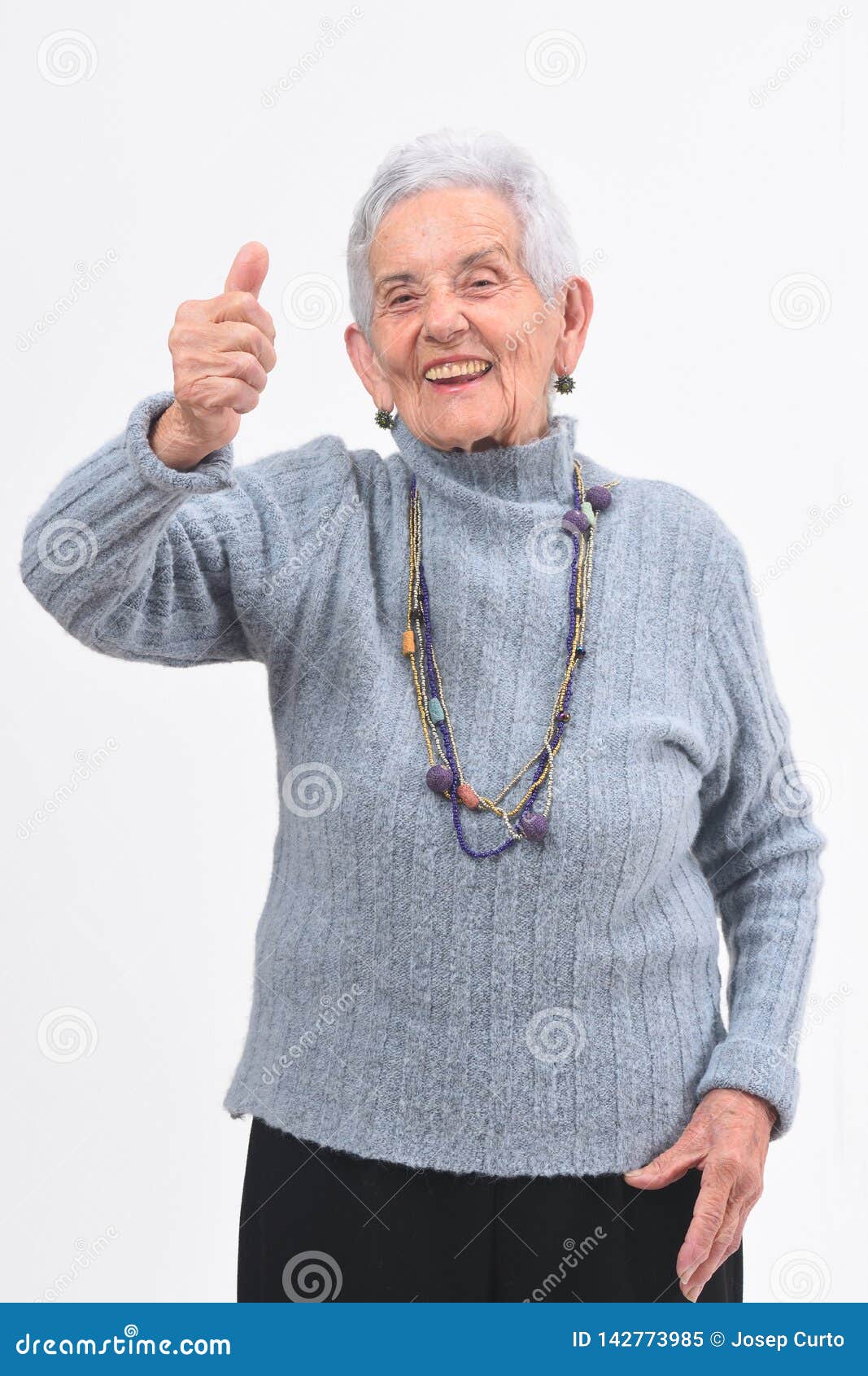 older woman with thumbs up and smile on white background