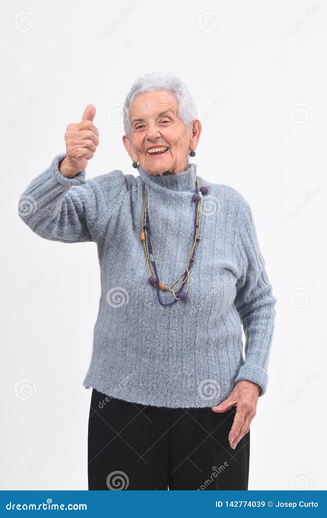 older woman with thumbs up and smile on white background