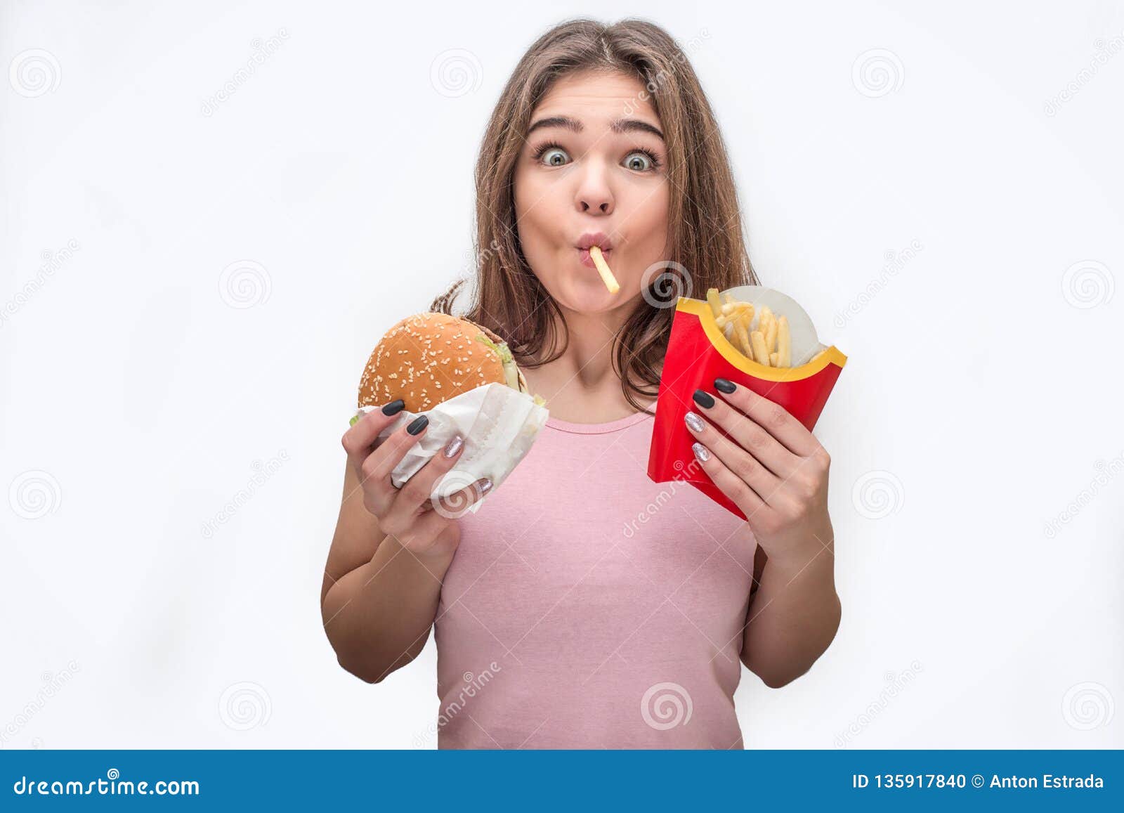 Mulher jovem comendo batata frita assistindo filme na mesa azul