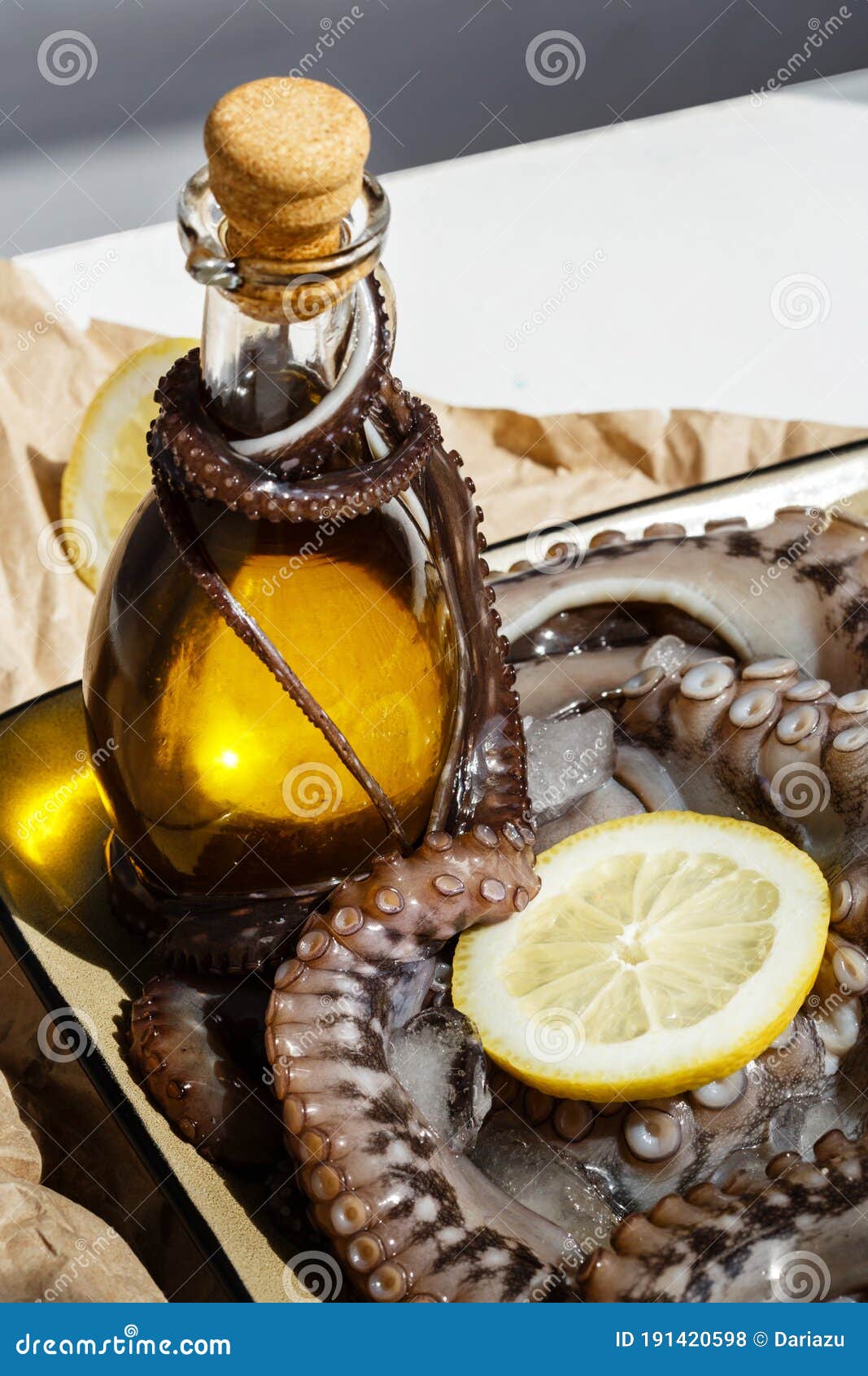 Olive Oil with Raw Octopus on a Plate with Lemons Ready for Preparing