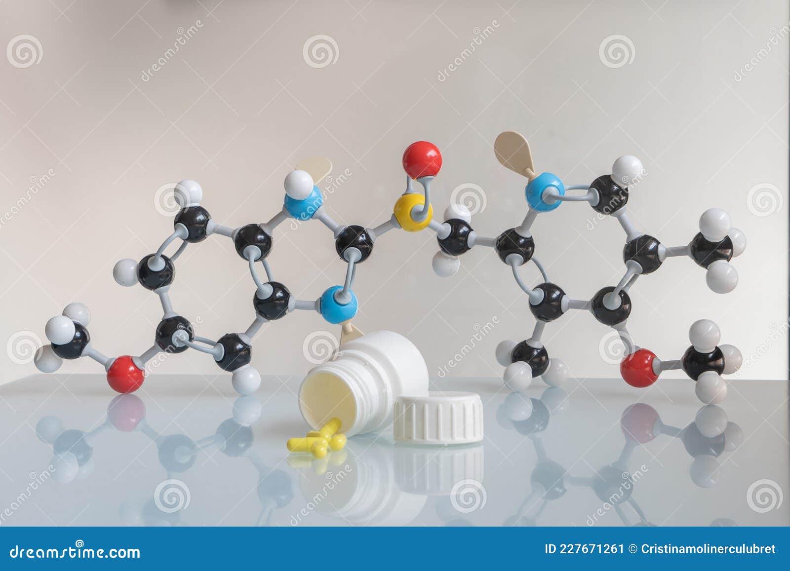 omeprazole pills and pill bote with omeprazole chemical formula made by molecular model in the background.