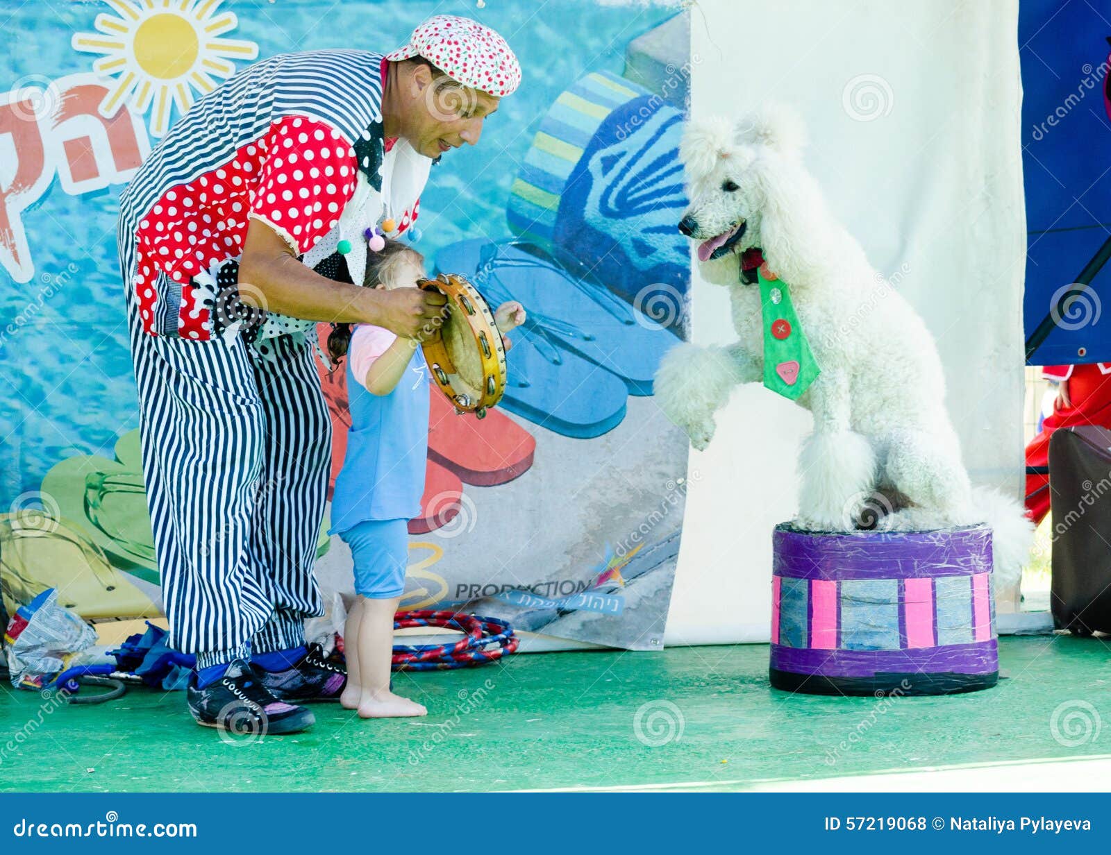 Omer (Beer-Sheva), ISRAEL Clown with a child playing with a white poodle , July 25, 2015. Beer-Sheva, ISRAEL Clown with a child playing with a white poodle , July 25, 2015 in Israel