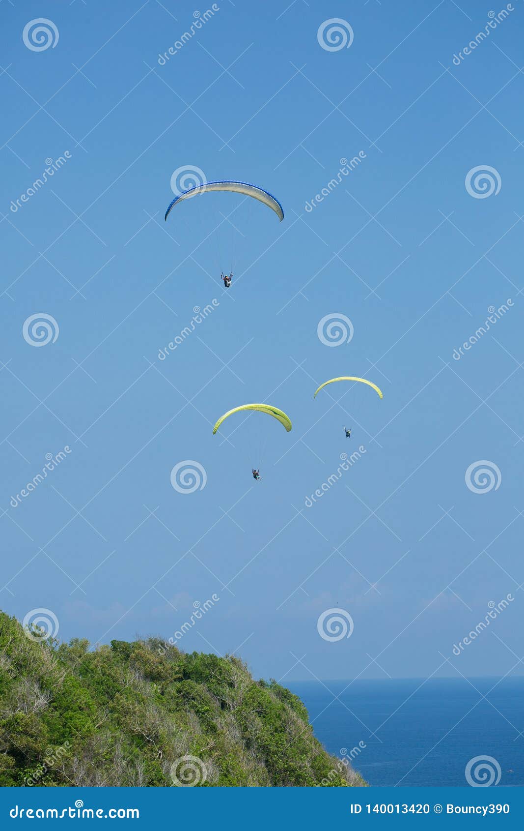 paragliders flying over bali, indonesia