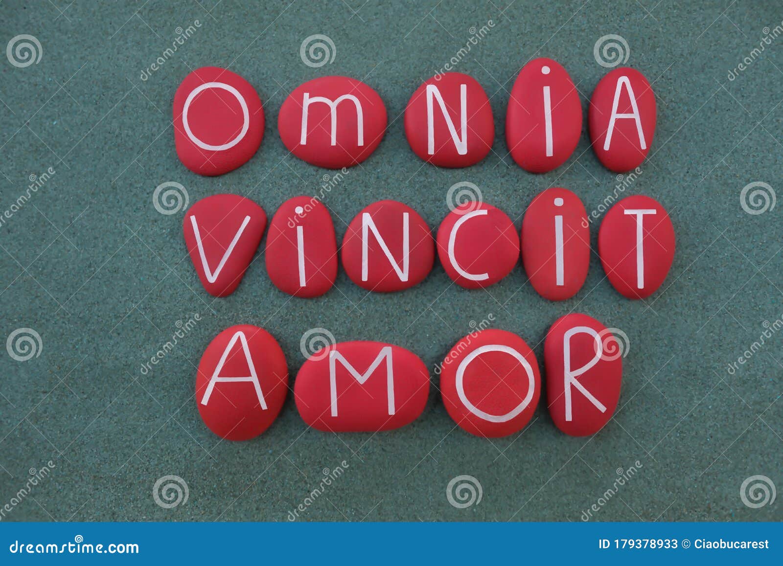 omnia vincit amor, love conquers all, latin phrase, virgil poet, text composed with red colored stone letters over green sand
