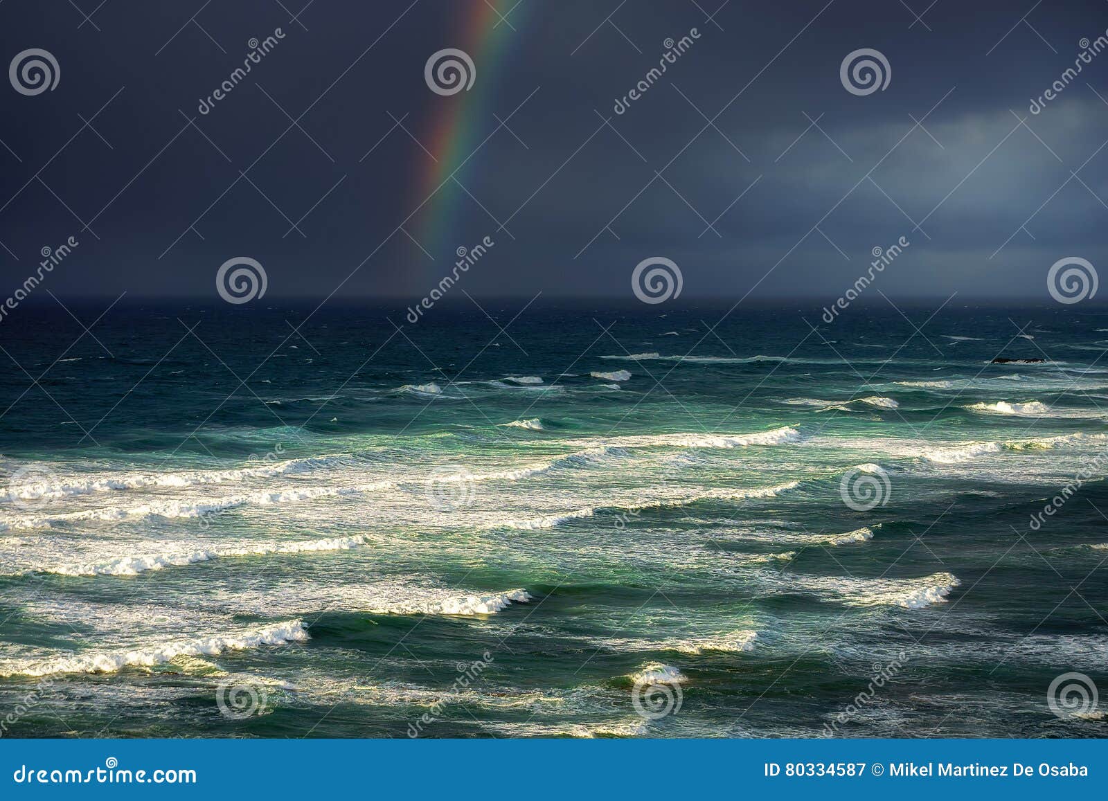 Onde in mare agitato con le nuvole e l'arcobaleno tempestosi. Onde in mare agitato con le nuvole tempestose e un arcobaleno