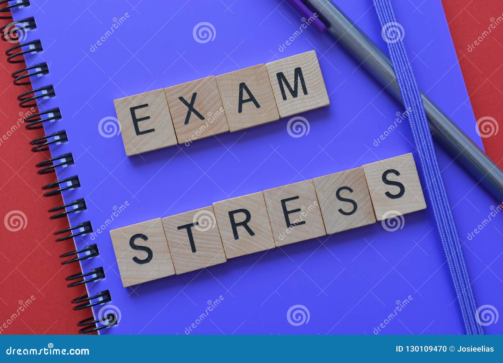 Onderwijs, examenspanning op notitieboekje. De Spanning van het woordenexamen in houten brieven op een purpere spiraal wordt beschreven - verbindend notitieboekje met een pen die Conceptueel die zaken en onderwijs, spanning door examens en tests wordt veroorzaakt