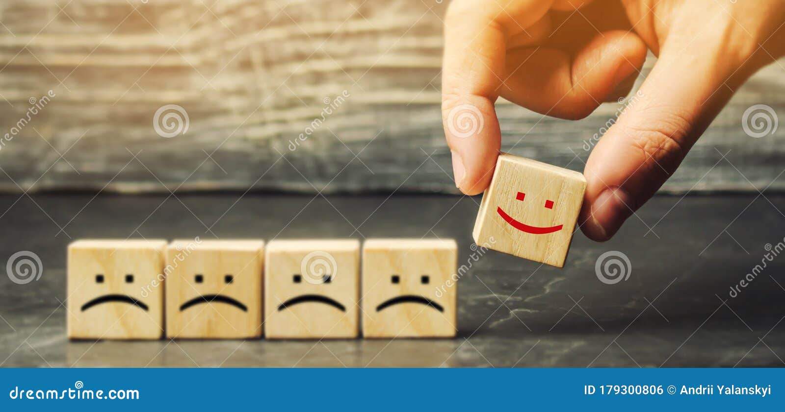one block with a positive face stands out from the rest of the negative emotions. concept of good rating, review and feedback.