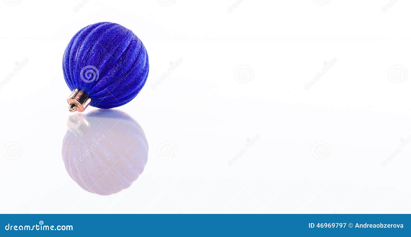 one blue christmas ball  on white reflective perspex background