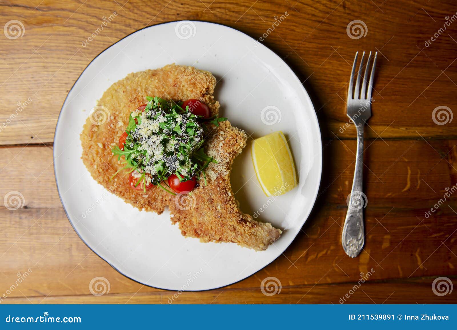 One Deep Fried Fish Bone Steak with Cherry Tomatoes and Fresh Arugula