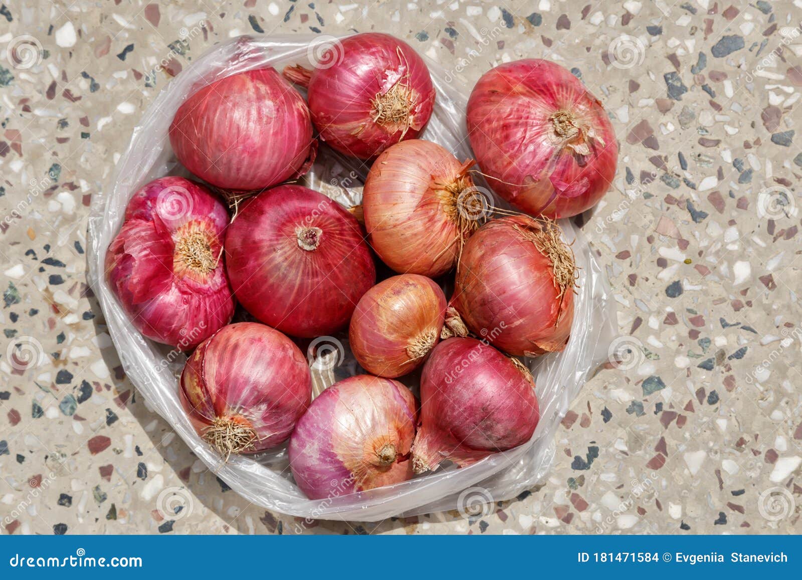 One Kilogram of Red Onions in a Plastic Bag on Concrete Floor Stock