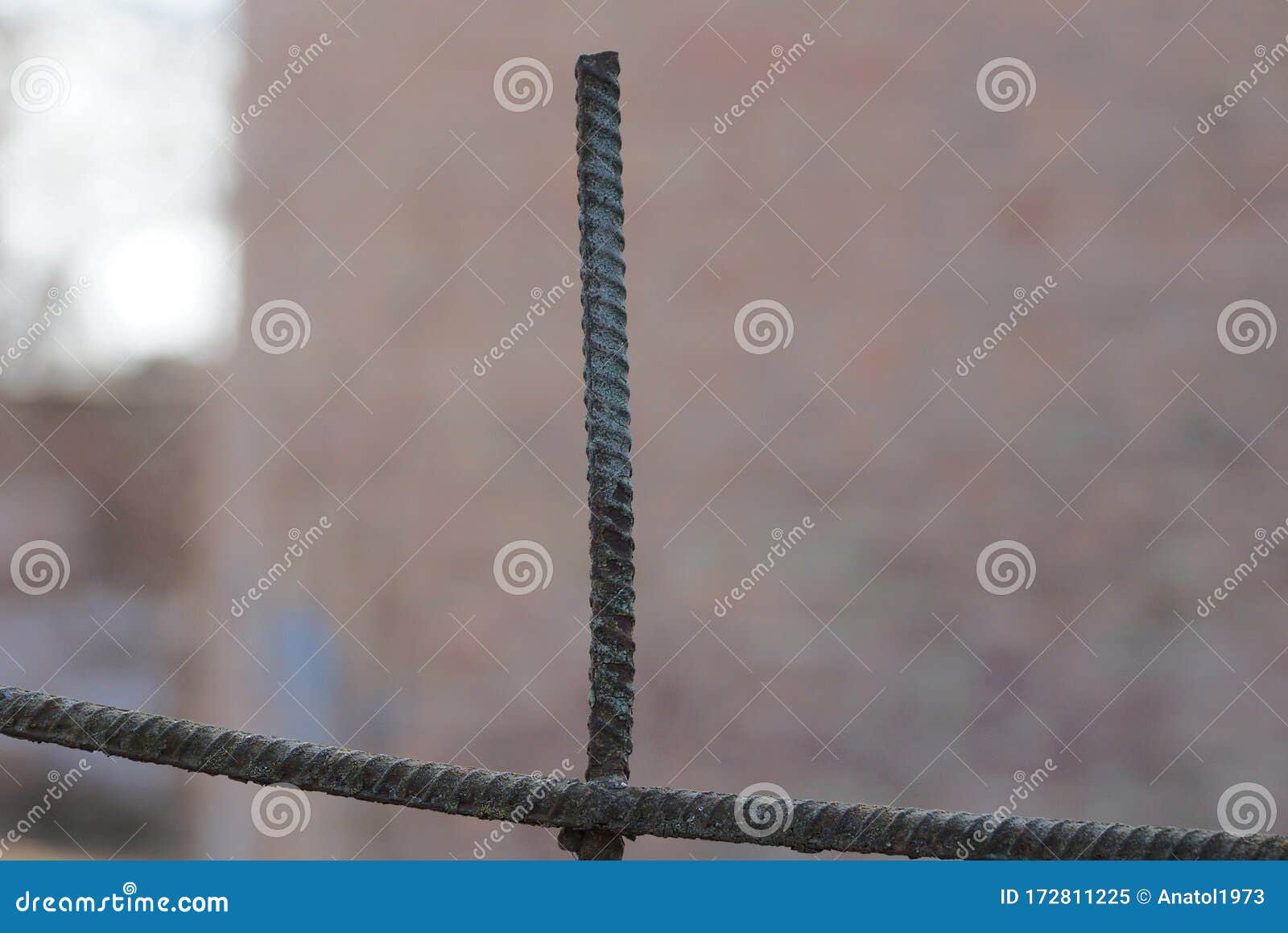 One Long Brown Iron Rod From Rebar In Rust On A Blue Background